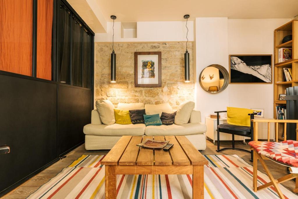 un salon avec un canapé et une table dans l'établissement Le Petit Nid - 2 personnes - Paris 3 - Terrasse, à Paris