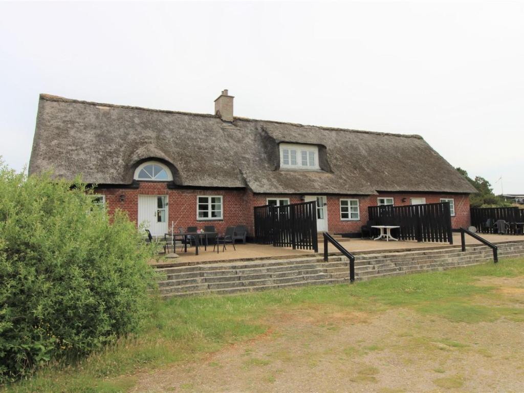 an old house with a thatched roof with tables and chairs at Apartment Withar - all inclusive - 800m from the sea by Interhome in Fanø