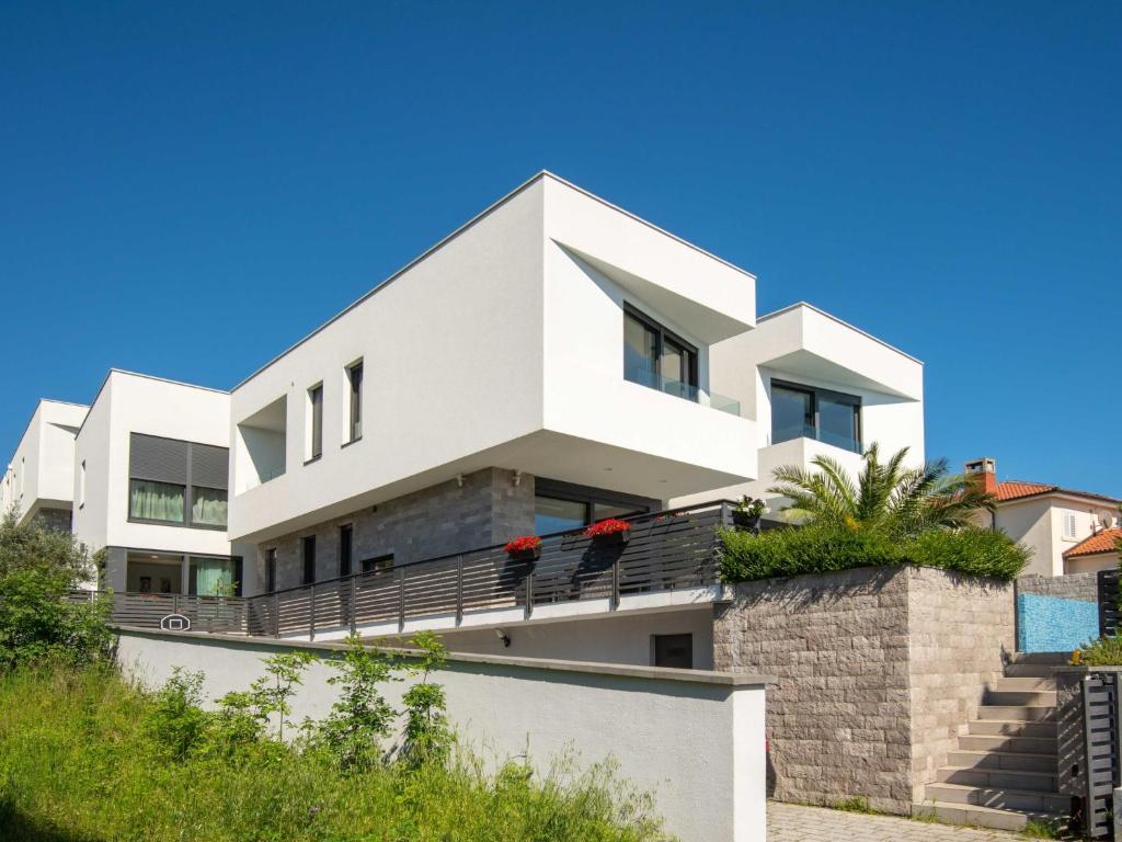 een wit huis met twee vogels op een balkon bij Apartment Oliva 2 by Interhome in Kostrena