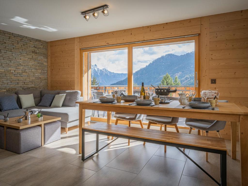 ein Wohnzimmer mit einem Tisch und einem großen Fenster in der Unterkunft Apartment L' O 12 by Interhome in Ovronnaz