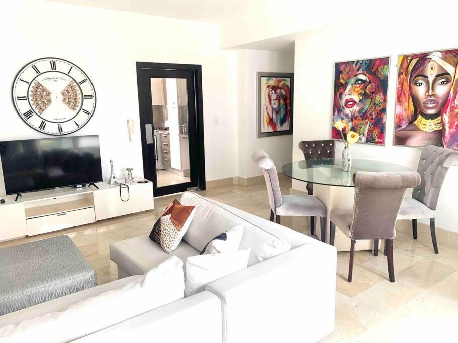 ein Wohnzimmer mit einem weißen Sofa und einem Tisch in der Unterkunft SUPER Spacious Modern Relax/CiPLA/CECiLIP in Santo Domingo