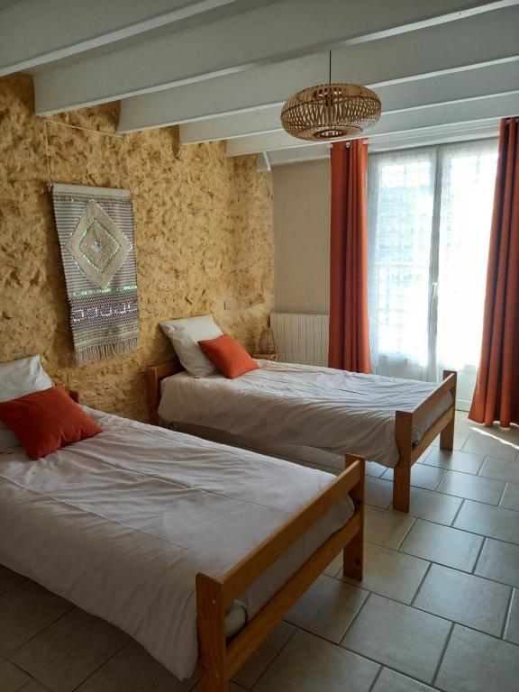 - une chambre avec 2 lits et un lustre dans l'établissement Gîte le Pech, à Sainte-Foy-de-Longas