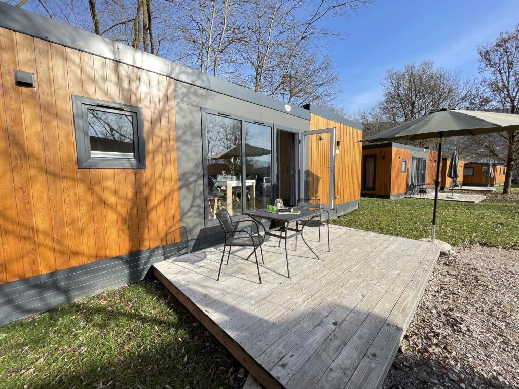 a table and chairs on a deck outside of a tiny house at Holiday Home Tiny Haus Auszeit by Interhome in Riedenburg