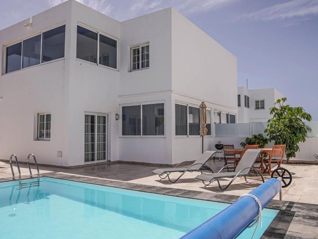 a swimming pool in front of a house at Villa Villa Marina by Interhome in Playa Blanca