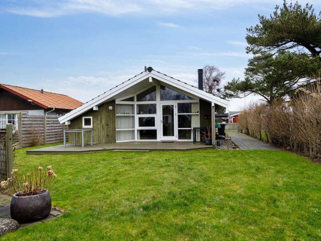 een huis met een groot raam en een tuin bij Holiday Home Hereth - all inclusive - 100m from the sea by Interhome in Otterup