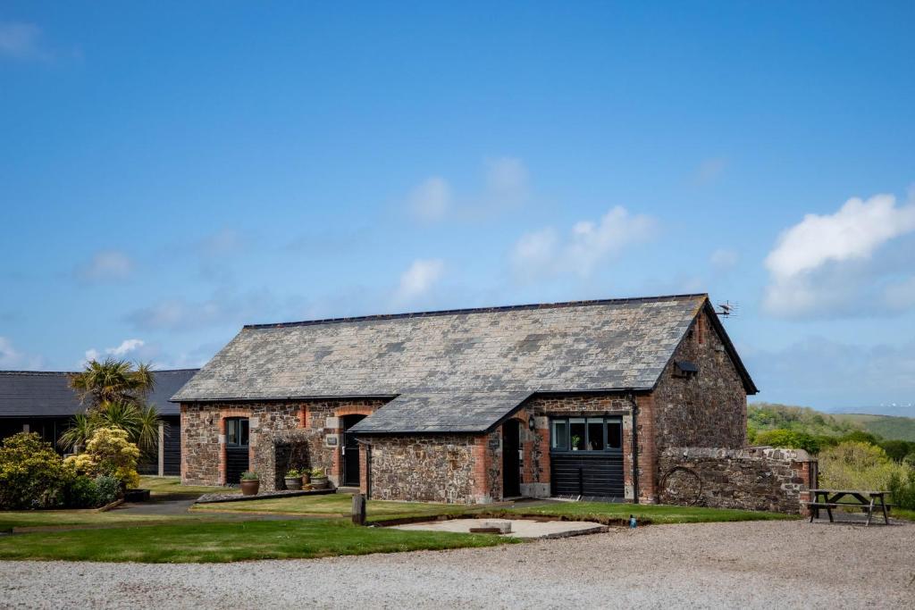una antigua casa de piedra con techo gris en Treworgie Barton - Trespaddick, en Bude