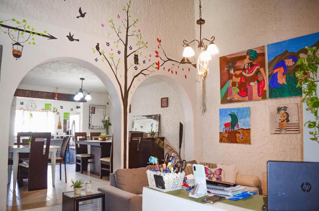 ein Wohnzimmer mit einem Tisch und einem Baum in der Unterkunft Naranjo Hostel in Cancún