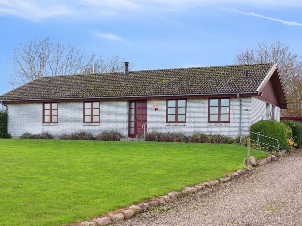 a white house with red windows on a green lawn at Holiday Home Sebine - all inclusive - 800m from the sea by Interhome in Humble