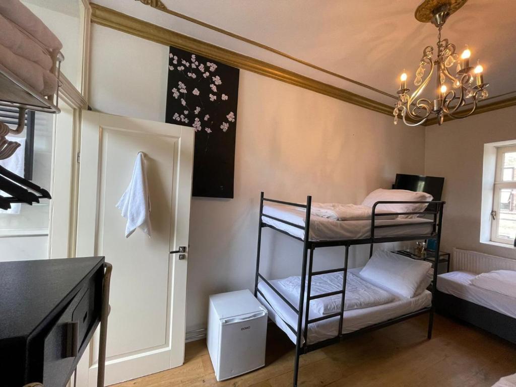 Zimmer mit 2 Etagenbetten und einem Kronleuchter in der Unterkunft Amsterdam Rembrandt Square city center Hotel in Amsterdam