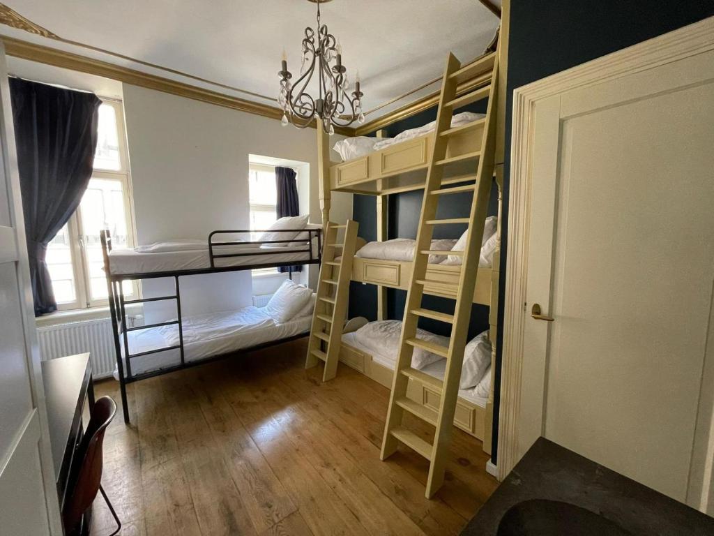 Zimmer mit 4 Etagenbetten und einem Kronleuchter in der Unterkunft Amsterdam Rembrandt Square city center Hotel in Amsterdam