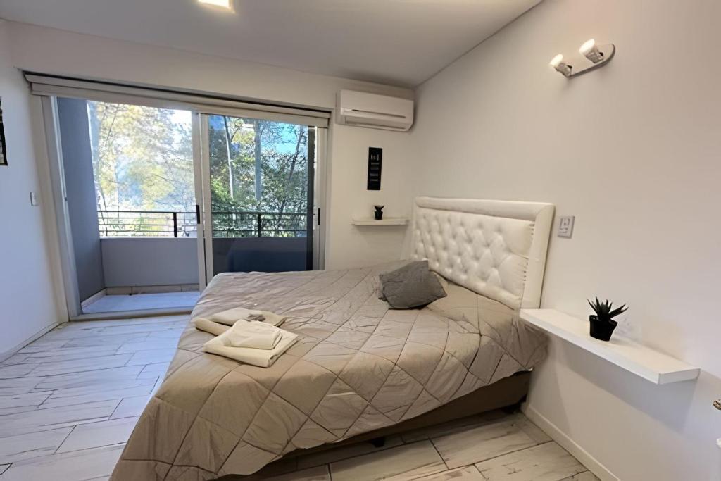a bedroom with a bed and a large window at Estudio Ejecutivo con Amenities in Rosario