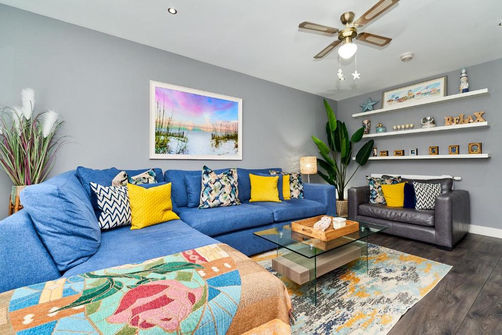 a living room with a blue couch and a ceiling fan at Modern Clonsilla Townhouse Sleeps 6 in Dublin
