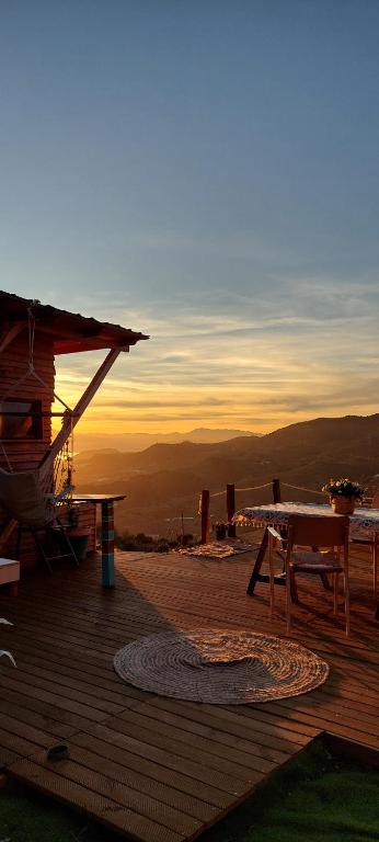 a wooden deck with a picnic table and a sunset at La Caravana de Sara in Rincón de la Victoria