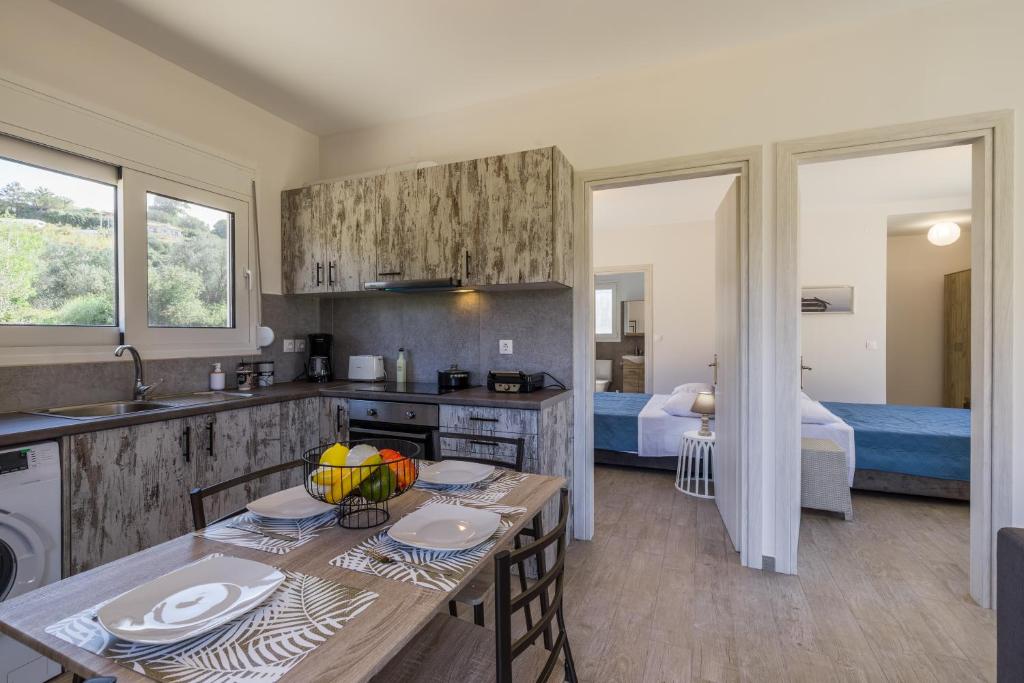 uma cozinha com uma mesa e um quarto com uma cama em Manos House - Elegant Modern Escape em Svoronata