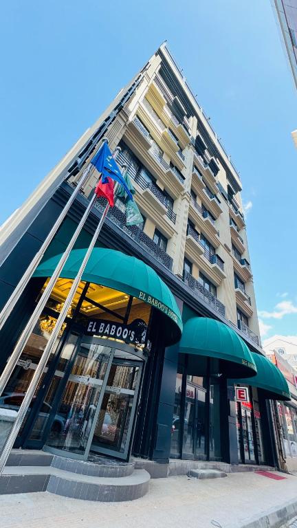 un edificio con dos sombrillas verdes delante en El Baboos Hotel, en Bostaniçi