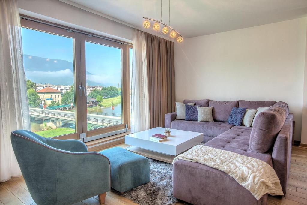 ein Wohnzimmer mit einem Sofa und einem großen Fenster in der Unterkunft VIP Apartments in Sarajevo
