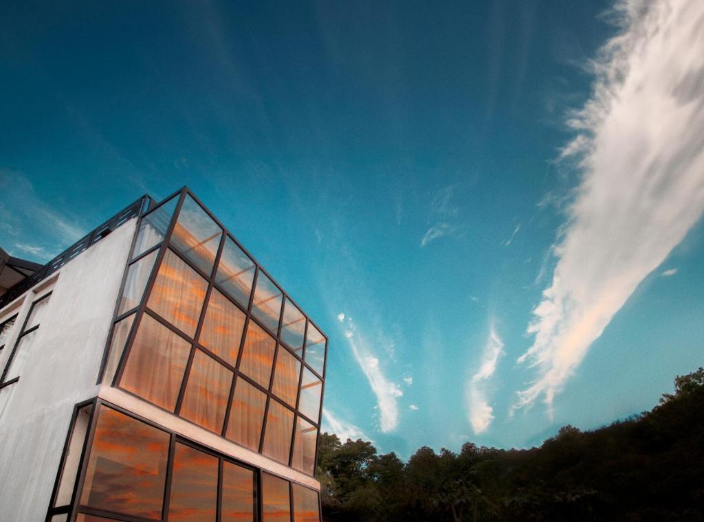 un bâtiment avec des fenêtres en verre et un ciel bleu dans l'établissement Flores Passport House, à Ende