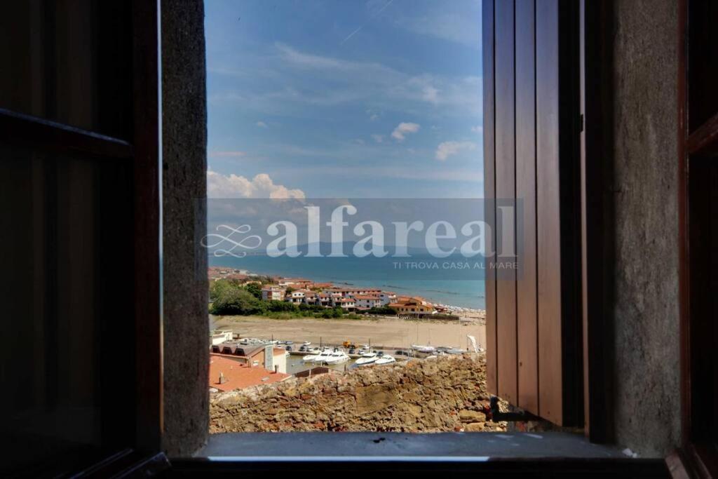 an open window with a view of a beach at Fortezza, vista mare nel centro del borgo medioevale in Castiglione della Pescaia