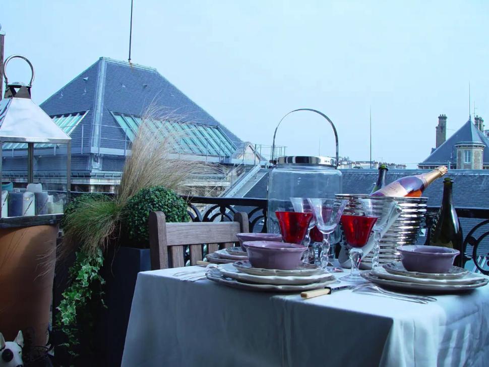 - une table avec des verres à vin rouge sur le balcon dans l'établissement Villa Eiffel, à Paris