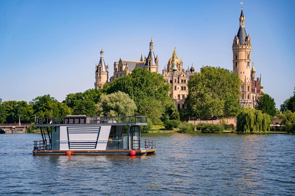 um barco na água em frente a um edifício em COSY Explorer - führerscheinfrei em Schwerin