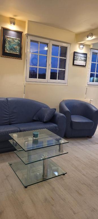 un salon avec un canapé et une table en verre dans l'établissement L'ARRA DE LA ROSERAIE, à Bonnebosq