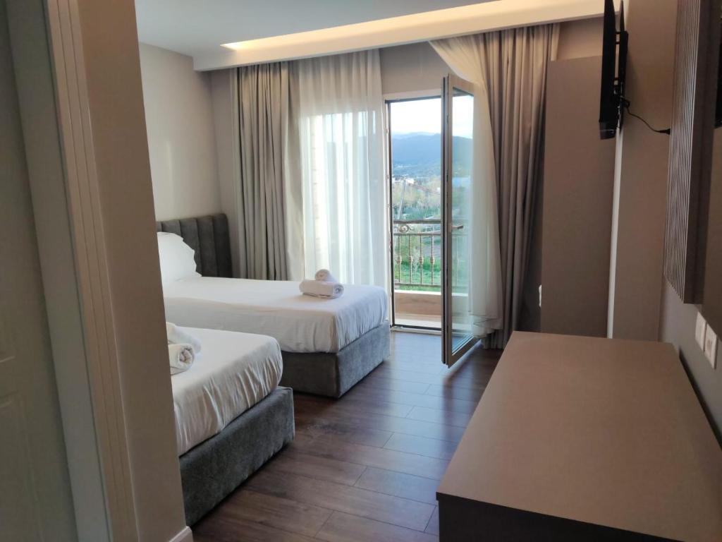 een hotelkamer met 2 bedden en een balkon bij DIMAL CASTLE in Poshnje
