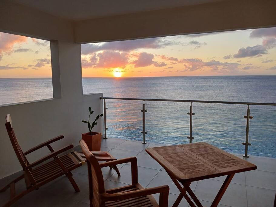 a balcony with a table and chairs and a view of the ocean at Blue Lagun Apartment B in Willemstad