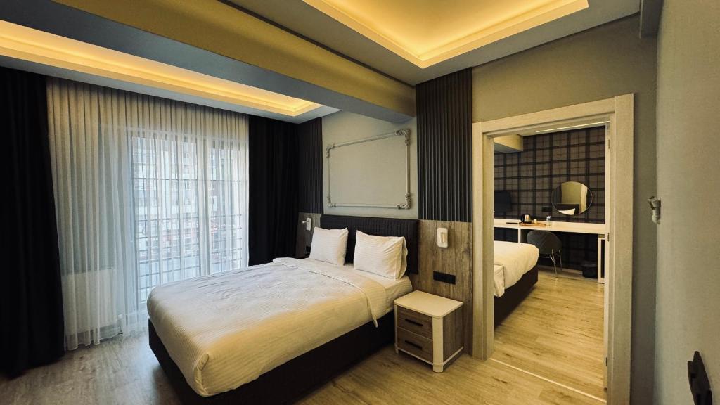 ein Hotelzimmer mit einem großen Bett und einem Schreibtisch in der Unterkunft El Baboos Hotel in Bostaniçi
