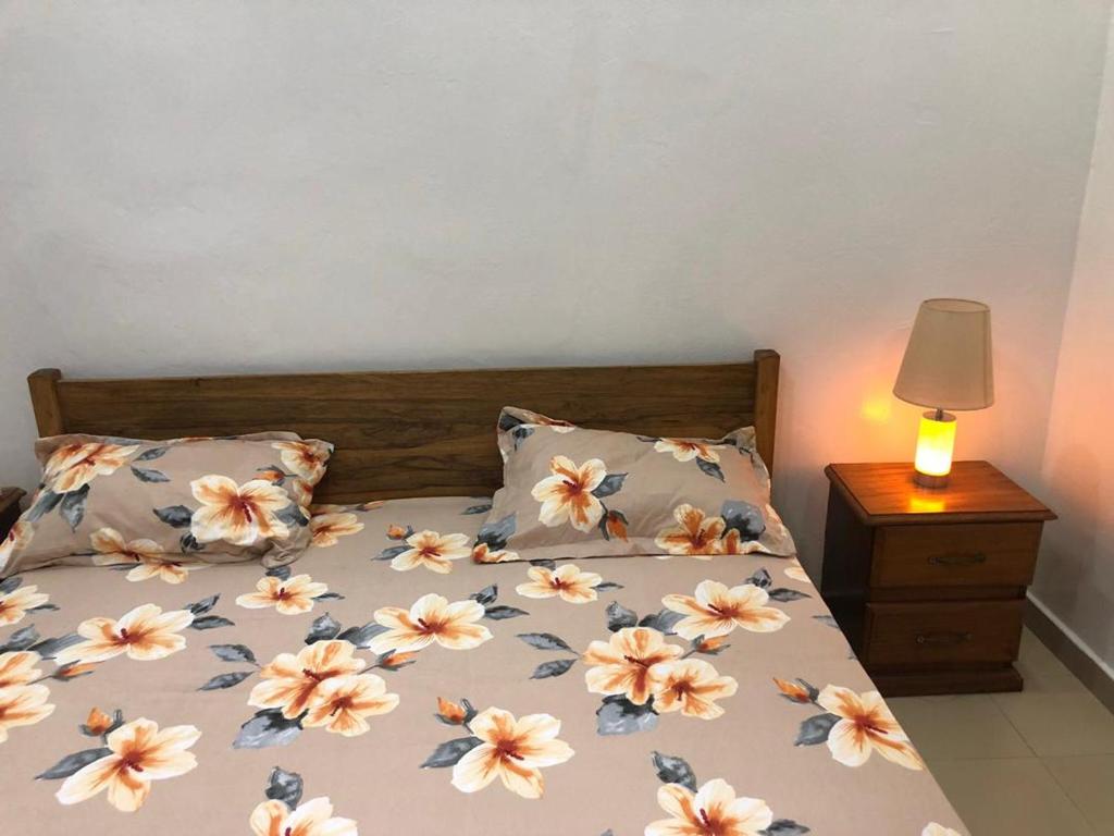 a bedroom with a bed with flowers on it at Jardin de Fann in Dakar