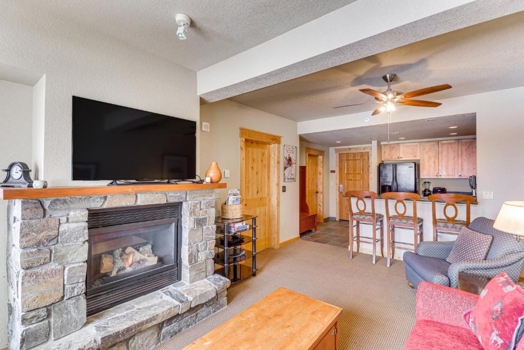 sala de estar con chimenea y TV de pantalla plana en Whitefish Mountain Condo - Ski Resort On-Site! en Whitefish