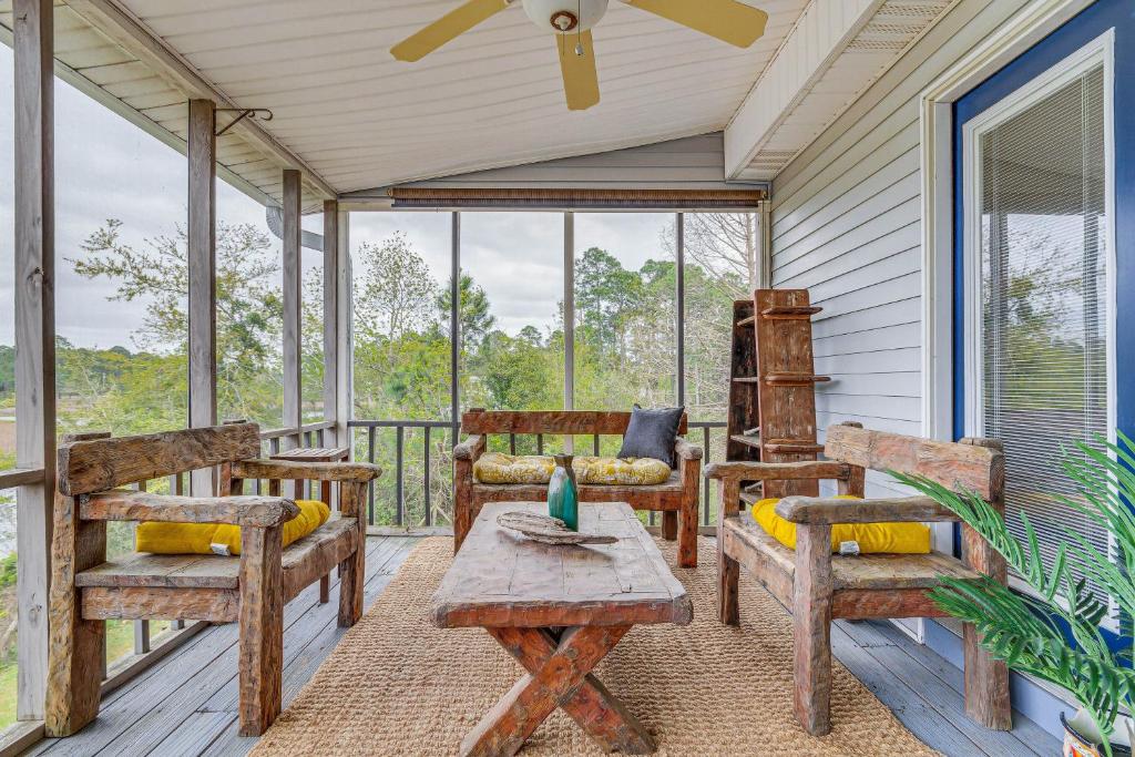 un porche cubierto con sillas y mesa en Milton Waterfront Home with Dock and Outdoor Kitchen!, en Milton