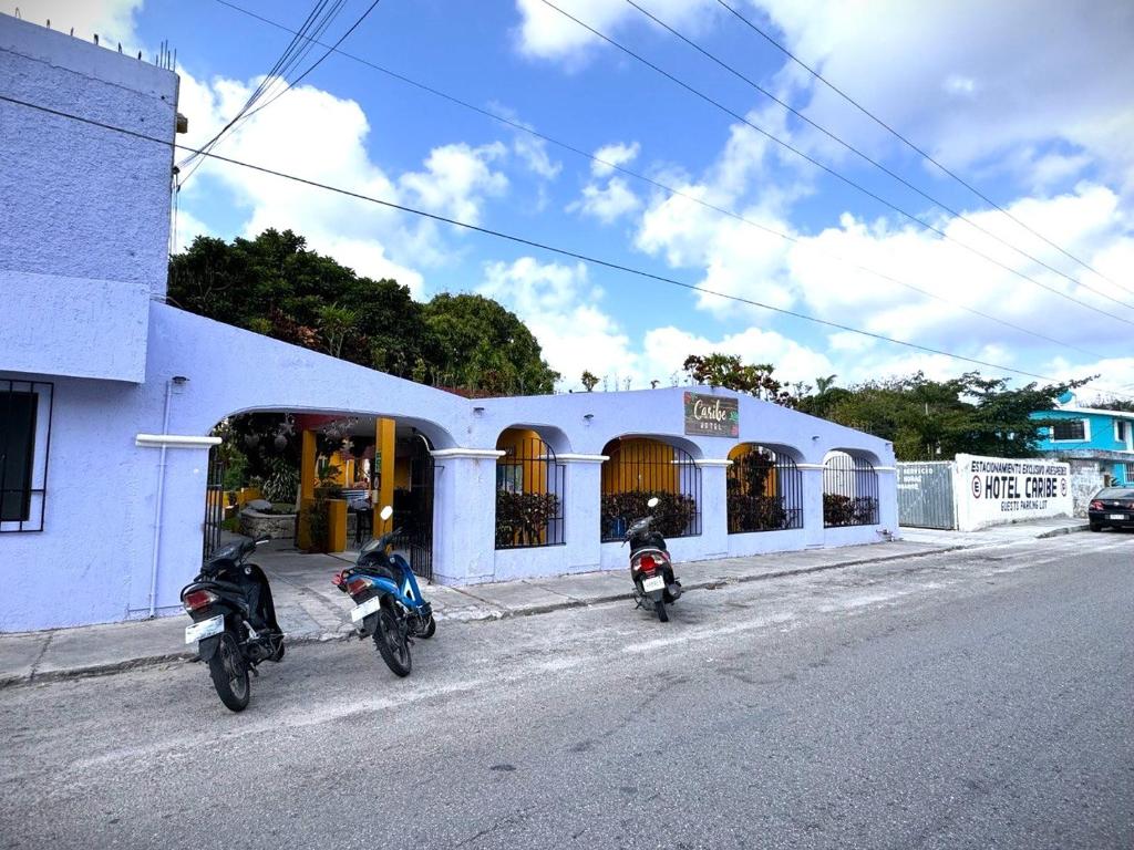 due moto parcheggiate di fronte a un edificio di Hotel Caribe a Cozumel