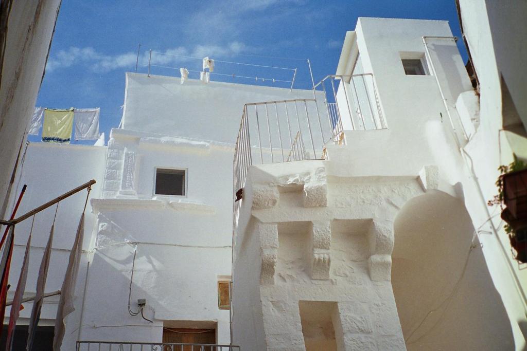 een wit gebouw met een trap en een blauwe lucht bij Casa Mario in Cisternino