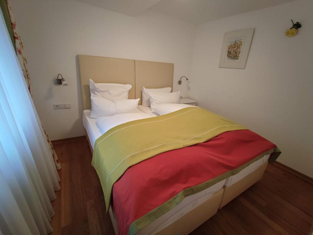 福爾巴克的住宿－Room in Guest room - Pension Forelle - Suite，一张床上有五颜六色的毯子,放在房间里