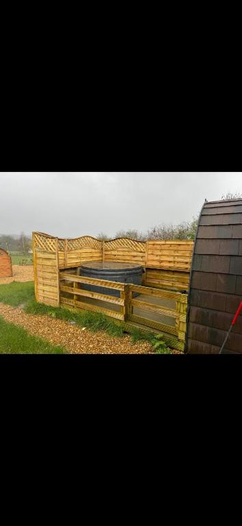 a wooden fence on the side of a field at New hotub glamping pods in Kinlet