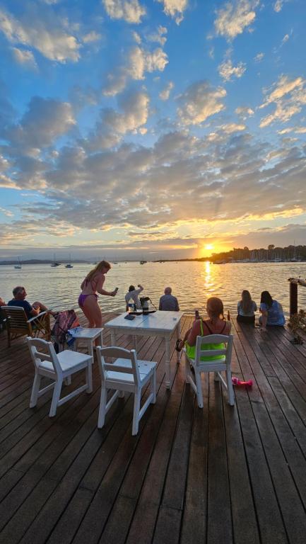 eine Gruppe von Menschen, die auf einem Steg am Tisch sitzen in der Unterkunft Hotel Blue Olas in Bocas del Toro