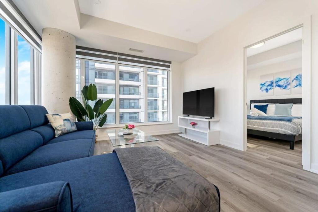 een woonkamer met een blauwe bank en een tv bij Upscale 1BR Condo with King Bed and Amazing Cityscape Views in Kitchener