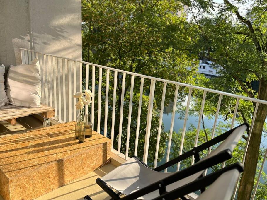 d'un balcon avec une chaise et un banc sur une terrasse couverte. dans l'établissement Nid ensoleillé & vue Seine, à Villeneuve-la-Garenne