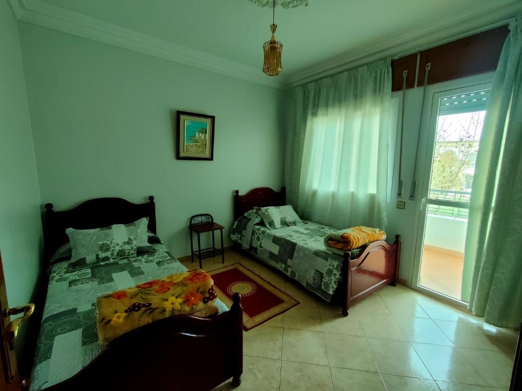 una camera da letto con due letti e una finestra di La Luna Rentals a Asilah