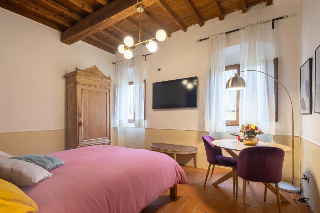 a bedroom with a pink bed and a table at Ardiglione Flat in Florence