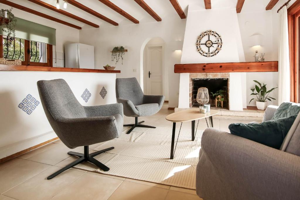uma sala de estar com duas cadeiras e uma lareira em Casa Bernia Vista em Benitachell