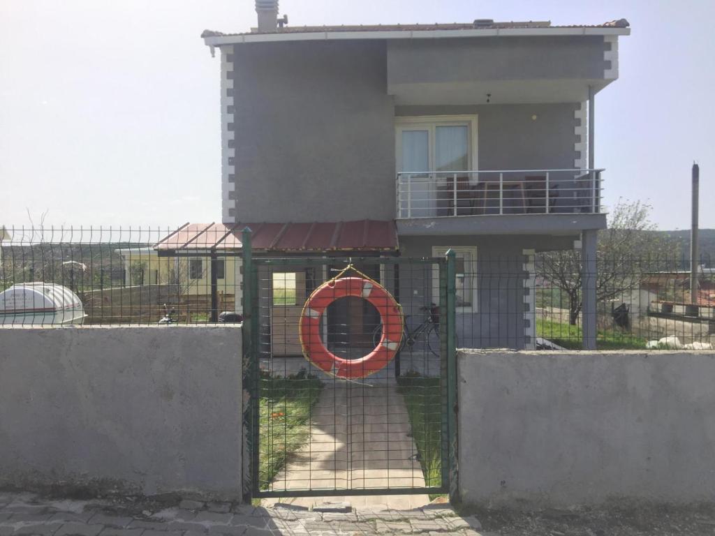a house with a gate with a life preserver on it at Güzelbahçe yemek atölyesi in İzmir