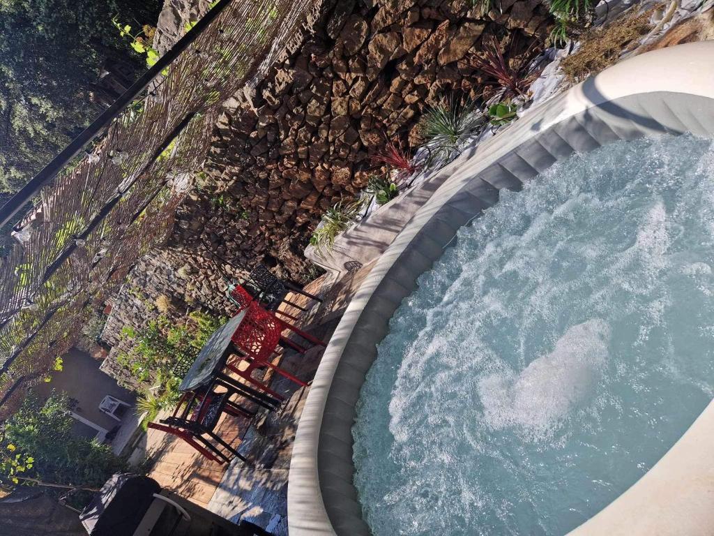 - une vue sur la piscine avec des chaises et de l'eau dans l'établissement La Magnanerie, à Mialet