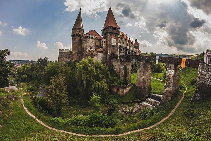 un viejo castillo en una colina con un puente en Affordable apartment close to the castle, en Hunedoara