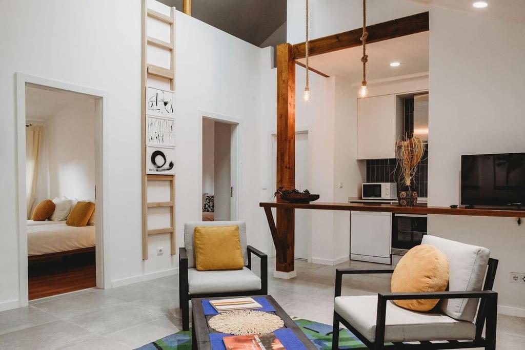 a living room with a bed and a table and chairs at Artist’s corner in central Caldas in Caldas da Rainha