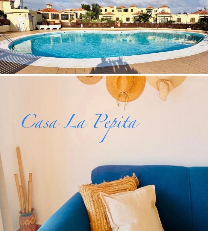 a living room with a blue couch and a swimming pool at Casa La Pepita Las Lomas 117 in Caleta De Fuste