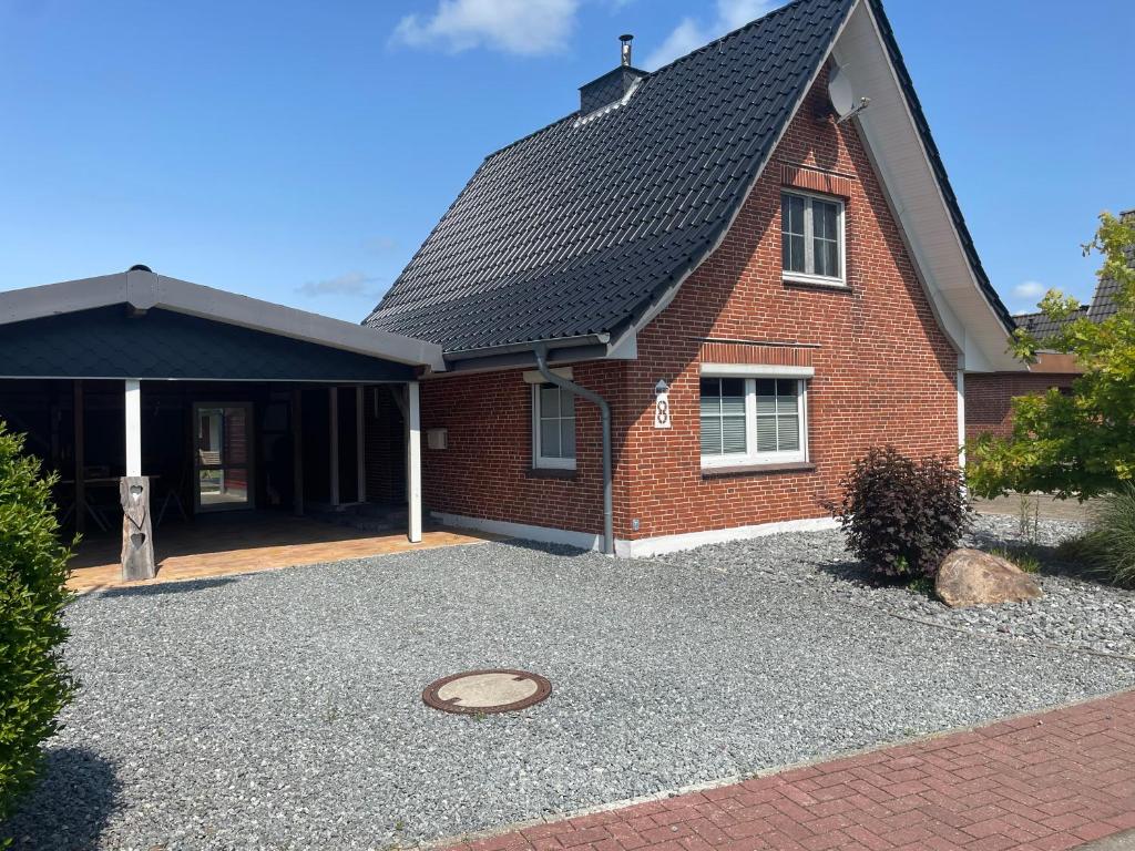 a red brick house with a gravel driveway at Ferienhaus Thomsen in Epenwöhrden