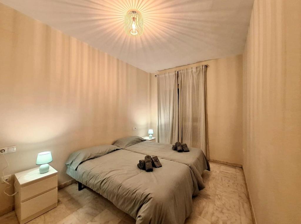 - une chambre avec un lit avec deux chaussures dans l'établissement APARTAMENTO TRIANA, à Séville