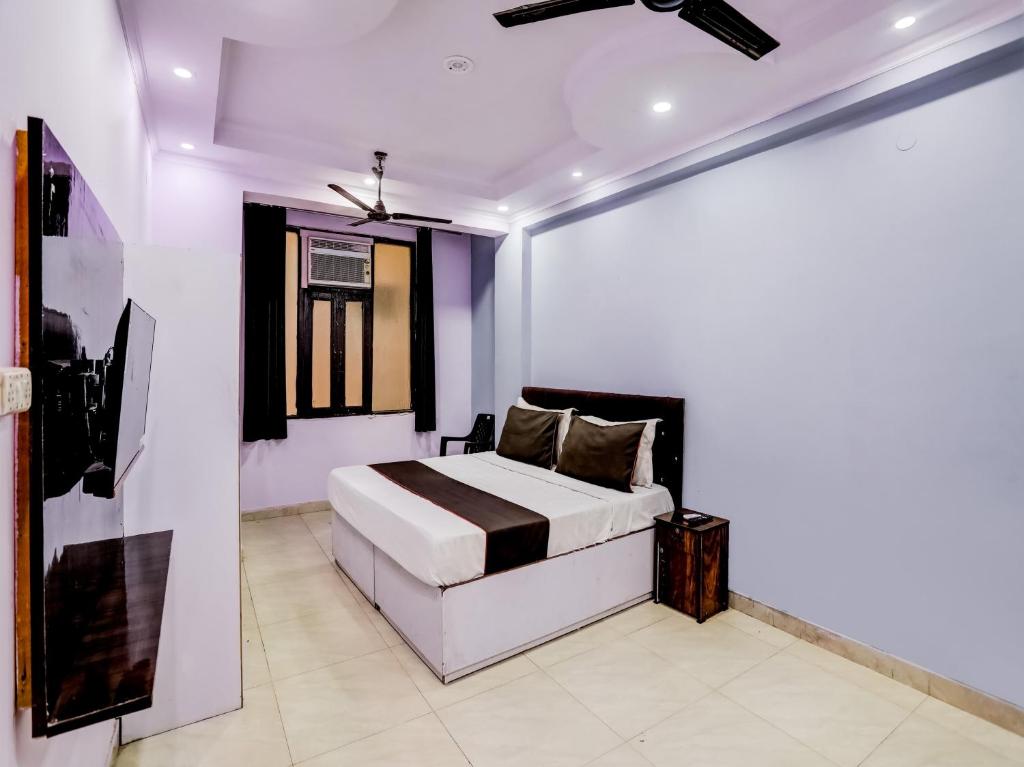 een slaapkamer met een bed en een schilderij aan de muur bij Hotel Raaz Luxury Near Delhi Airport in New Delhi