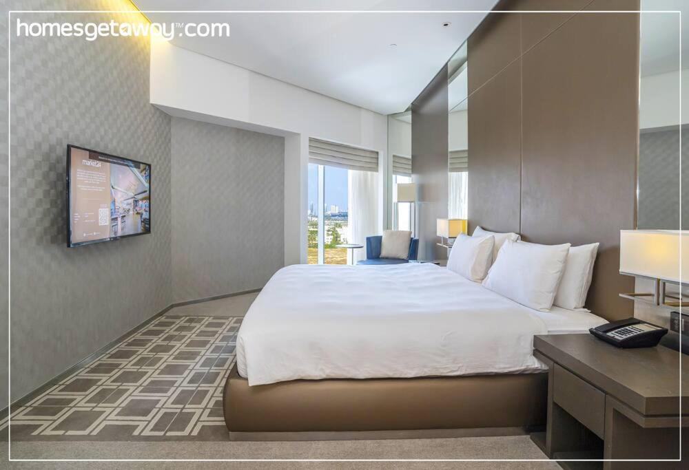 a hotel room with a large bed and a desk at Cozy 1BR Hyatt Creek Heights Residences in Dubai